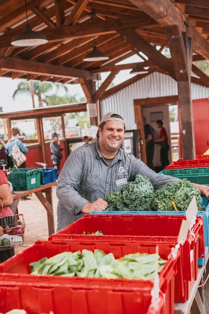 Man with bin of veggies