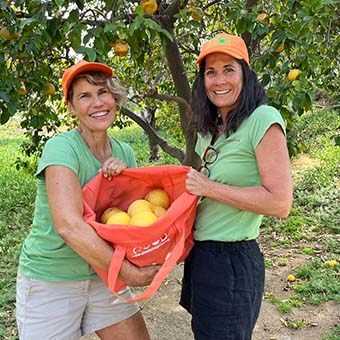 Women holding baskets of fruit