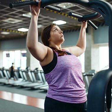 Woman at gym doing pull downs