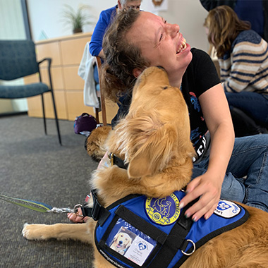 Woman hugging a golden retriever service dog