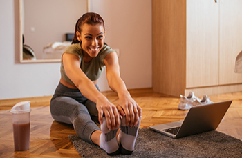 Woman exercises at home with online class